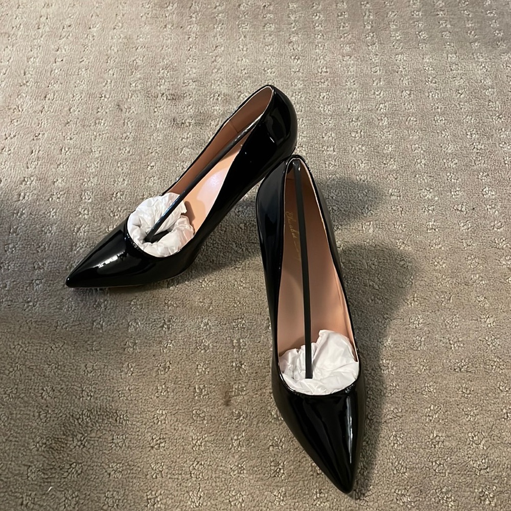 Woman’s shiny black pumps